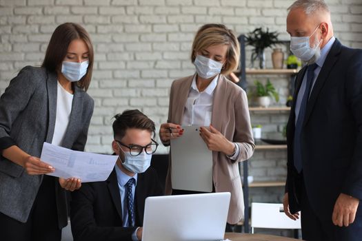 Business team in protective masks works in the office