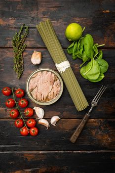 Uncooked Pasta with vegetables and tuna ingredients set, on old dark wooden table background, top view flat lay