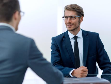 business partners talk sitting at a Desk.photo with copy space