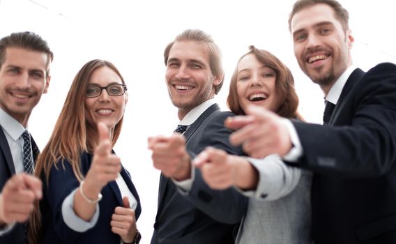 Happy business group poiting at the camera