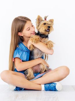 Sitting girl holds calm small dog