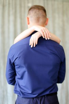 Back view of female hands hugging man. Concept of reationship and love.