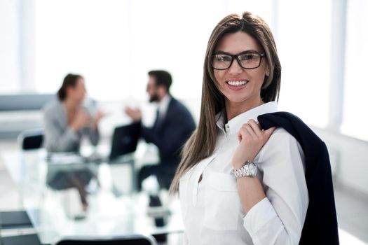 smiling business woman standing with a jacket over her shoulder.photo with copy space