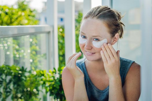 Portrait of Beauty Red-haired woman with eye patches showing an effect of perfect skin. Spa Girl.