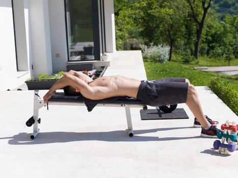 young handsome man doing morning exercises in front of his luxury home villa