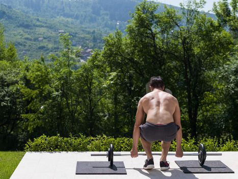 young handsome man doing morning exercises in front of his luxury home villa