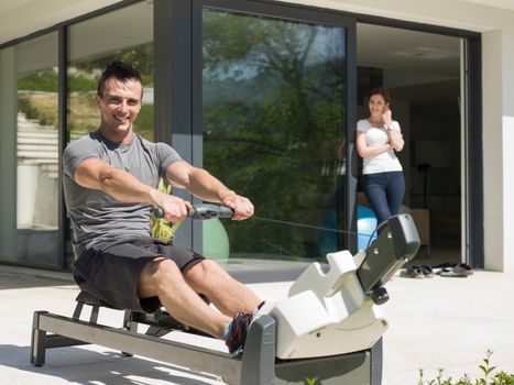 young handsome man doing morning exercises in front of his luxury home villa