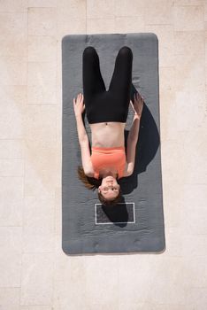 young handsome woman doing morning yoga exercises in front of her luxury home villa top view
