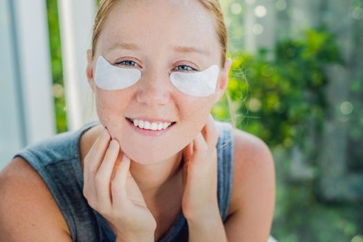 Portrait of Beauty Red-haired woman with eye patches showing an effect of perfect skin. Spa Girl.