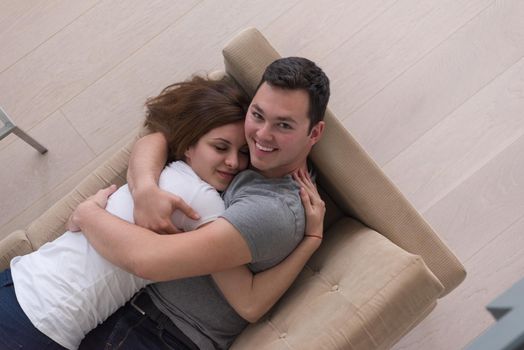 young handsome couple enjoys hugging on the sofa in their luxury home villa