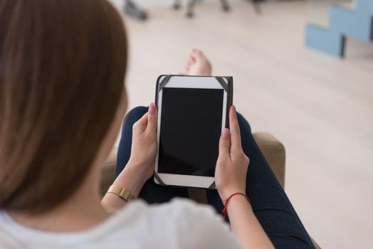 young happy woman sitting on sofa with tablet computer at luxury home