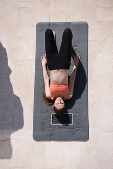 young handsome woman doing morning yoga exercises in front of her luxury home villa top view