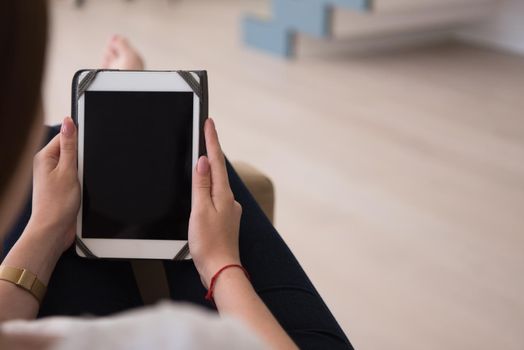 young happy woman sitting on sofa with tablet computer at luxury home