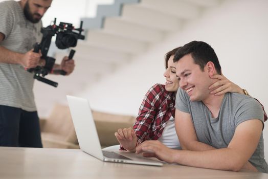 happy young couple buying online using laptop a computer and a credit card in their luxury home villa