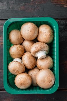 Royal mushrooms champignon whole set, on old dark wooden table background, in plastic pack, top view flat lay