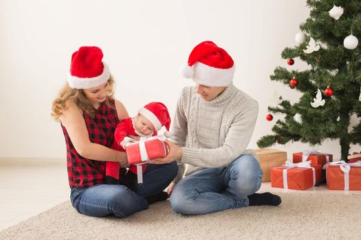 Happy couple with baby celebrating Christmas together at home