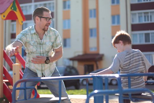 happy father playing with little boy on the Playground.the concept of parenting