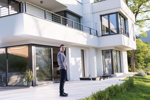 portrait of a young handsome successful man in front of his luxury home villa