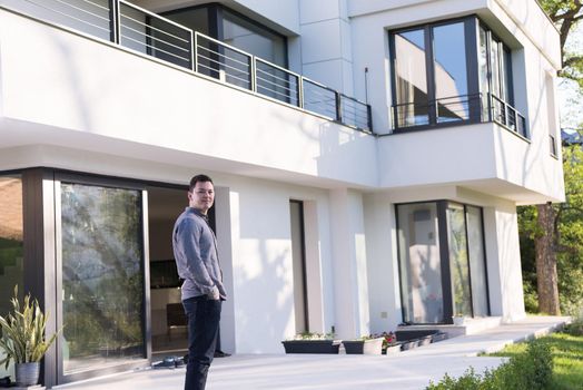 portrait of a young handsome successful man in front of his luxury home villa