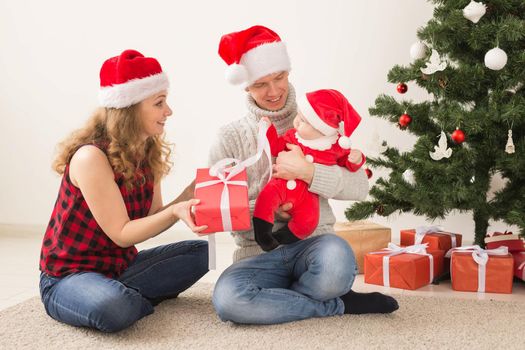 Happy couple with baby celebrating Christmas together at home