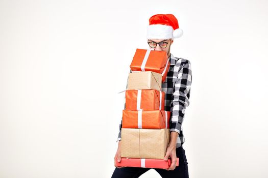 Holidays and presents concept - Funny man in Christmas hat holding many gift boxes on white background.