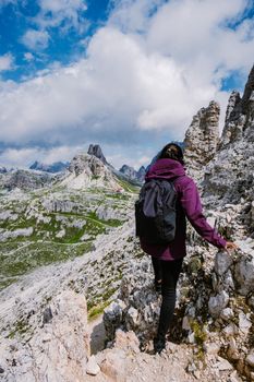 Tre Cime di Lavaredo peaks or Drei Zinnen at sunset, Dobbiaco Toblach, Trentino -Alto Adige or South Tyrol, Italy. Europe Alps. Asian woman hiking in the mountains