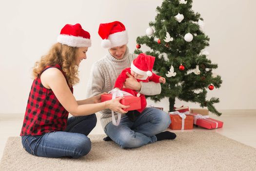 Happy couple with baby celebrating Christmas together at home