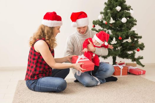 Happy couple with baby celebrating Christmas together at home