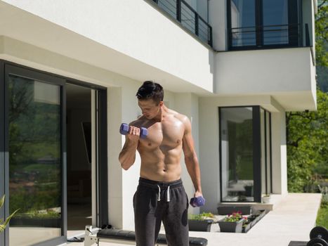 young handsome man doing morning exercises in front of his luxury home villa
