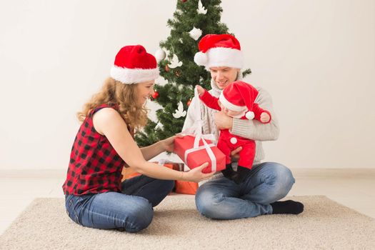 Happy couple with baby celebrating Christmas together at home