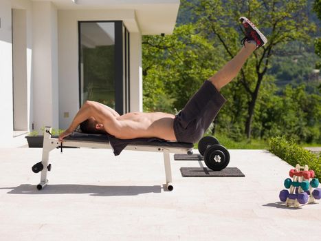 young handsome man doing morning exercises in front of his luxury home villa