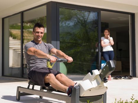 young handsome man doing morning exercises in front of his luxury home villa