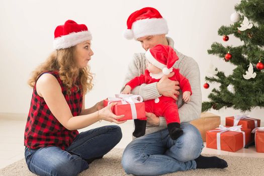 Happy couple with baby celebrating Christmas together at home