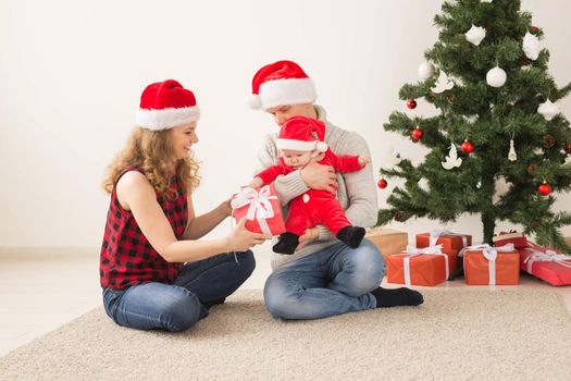 Happy couple with baby celebrating Christmas together at home