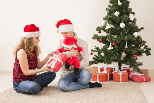 Happy couple with baby celebrating Christmas together at home