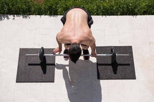 young handsome man doing morning exercises in front of his luxury home villa