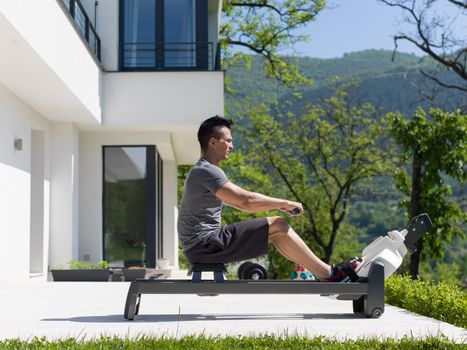 young handsome man doing morning exercises in front of his luxury home villa