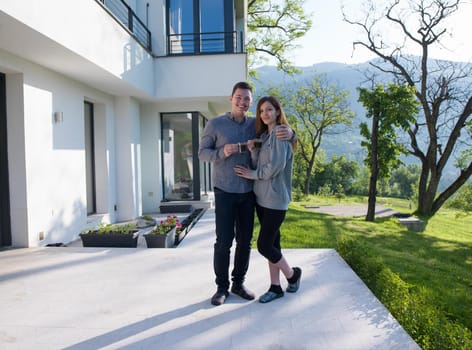 young beautiful handsome couple enjoying morning coffee in front of their luxury home villa