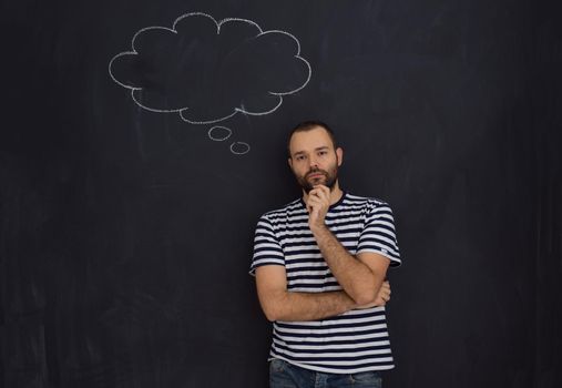 young future father thinking about names for his unborn baby to writing them on a black chalkboard