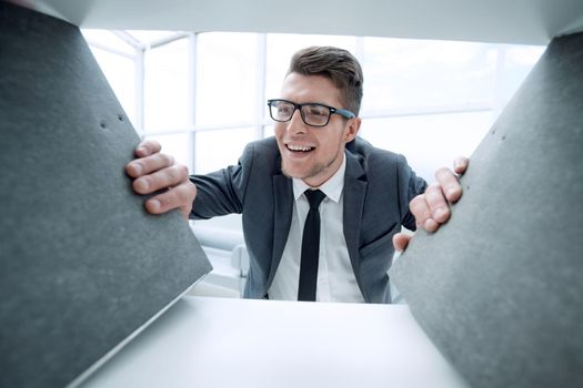 young businessman with glasses is smiling and looking at camera. is holding folders for documents