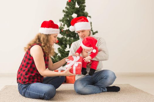 Happy couple with baby celebrating Christmas together at home