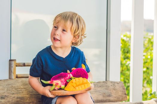 Diced dragon fruit and mango in the hands of the boy.