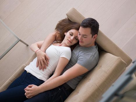 young handsome couple enjoys hugging on the sofa in their luxury home villa