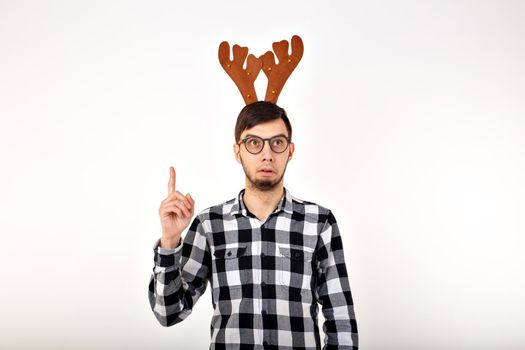 Christmas, holidays and funny concept - man with deer horns and rudolf nous.