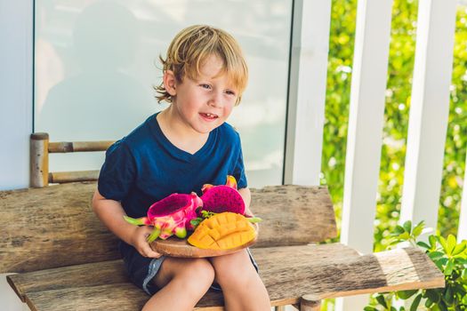 Diced dragon fruit and mango in the hands of the boy.