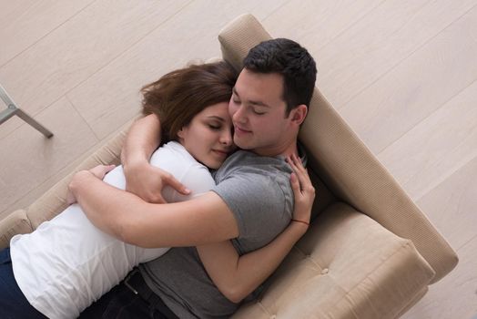 young handsome couple enjoys hugging on the sofa in their luxury home villa