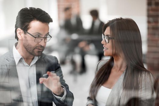 close up.business partners discussing something while standing near the office window