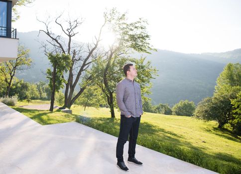 portrait of a young handsome successful man in front of his luxury home villa