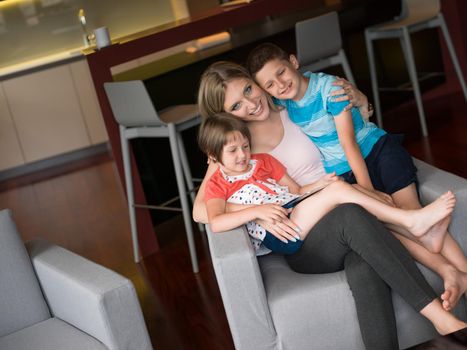 Happy Family Lying Down On The Sofa And Using Tablet