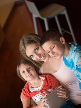 Happy Family Lying Down On The Sofa And Using Tablet